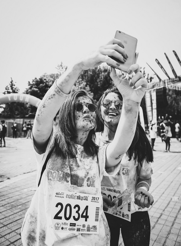 Two woman runners taking part a muddy selfie after the Mud Runners Championship